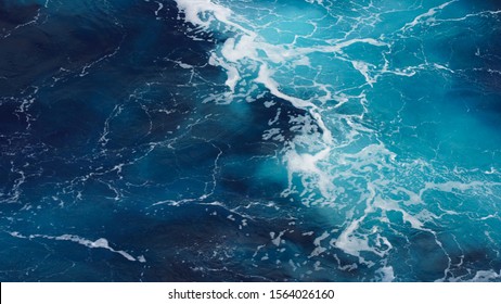 background pacific ocean, bright blue color of sea splashing wave, texture of sea foam. abstraction of ripped water waves in ocean sunlight. turbulent ocean composition. unusual structure of water.  - Powered by Shutterstock