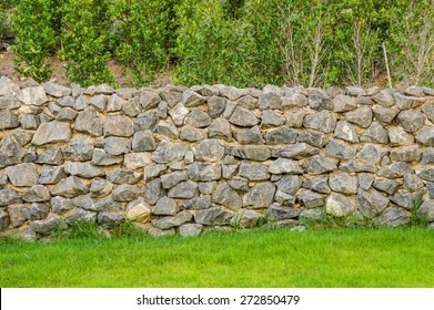background pattern gray color of modern style design decorative fence real stone wall surface with cement on green grass field