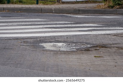 background, pattern. natural patterns from water and frost on the sidewalk. frozen puddle in front of a pedestrian crossing in the countryside
