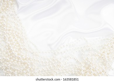 Background with pearls. Focus on satin
