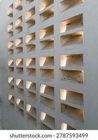 The background of the perforated wall implies the twilight light of the house wall