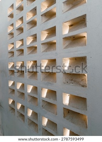 The background of the perforated wall implies the twilight light of the house wall