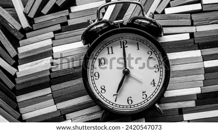 Background photo of an alarm clock showing 7:00 o'clock, black and white concept
