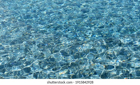 Background picture. Swimming pool bottom ripple and with waves background. Summer background. Texture of water surface.