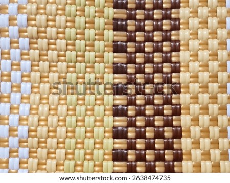 Background of plastic woven texture with brown, cream and white checkered pattern. Plastic woven handicraft is made of friendly recycled plastic material for decoration, baskets, bags and other diary.