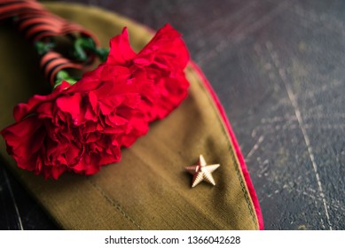 background for postcards by may 9, victory day: cap, letters, carnations and St. George ribbon - Shutterstock ID 1366042628