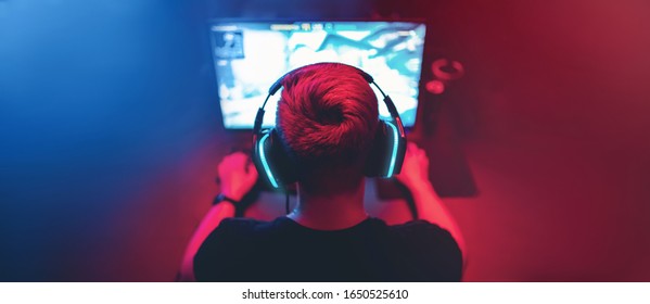 Background professional gamer playing tournaments online games computer with headphones, red and blue. - Shutterstock ID 1650525610