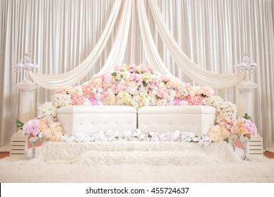 Hintergrund einer Hochbühne, auf der Brautjungfern und Brautjungfern in einer traditionellen englischen Hochzeit mit bunten Blumen sitzen