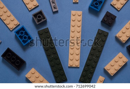 The background of random colored plastic building blocks, pattern on blue background