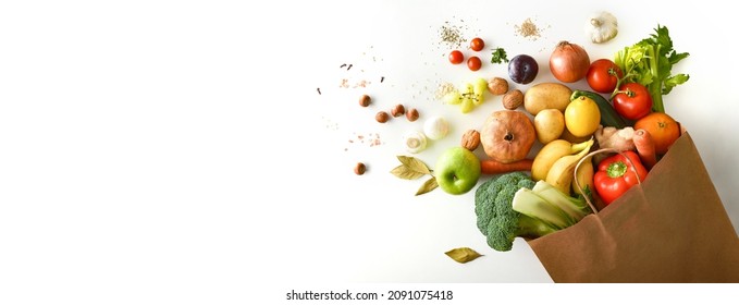 Background with recyclable brown paper shopping bag with fruits and vegetables on white table. Top view. Horizontal composition. - Powered by Shutterstock