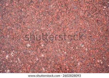 background with red granite tile texture. The texture of natural granite stone for the decoration of facades and sidewalks