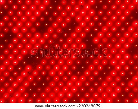 Background of red LED lamps, LED strip, red flashing lights, LED pads, red color background with light dots, space for text, photo of a real LED panel, flashing lights on the wall