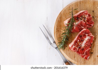 Background With Red Meat And Rosemary Over White Wooden Table. Top View