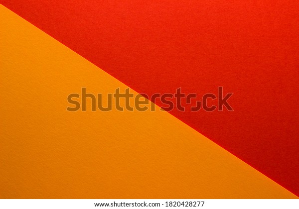 Background of\
red and orange paper divided diagonally. Sheets of blank orange and\
red paper with fine texture, close\
up.