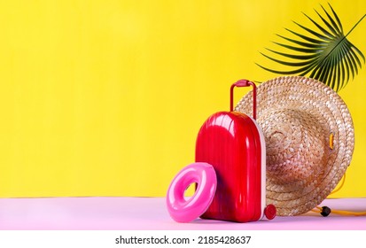 Background With Red Suitcase, Rubber Ring And Straw Hat On Yellow. Travel Composition. Summer Vacation Concept. Mockup With Copy Space