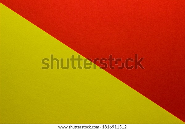 Background of\
red and yellow paper divided diagonally. Sheets of blank yellow and\
red paper with fine texture, close\
up.