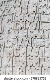 A Background Of  Roman Numerals And Letters Set In Stone