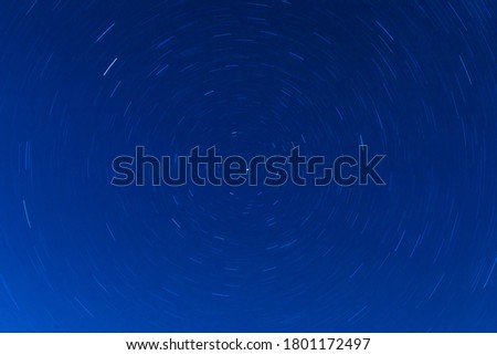 Background of round or circular star track or trajectory on the blue clear night sky. Symbol of space, cosmos, expanse infinity and universe