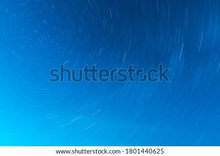 Background of round or circular star track or trajectory on the blue clear night sky. Symbol of space, cosmos, expanse infinity and universe