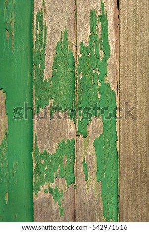 Background of rustic wooden planks with green peeling paint.