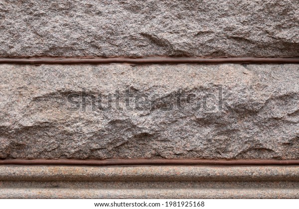 Background of\
rusticated granite blocks divided by beaded mortar, architectural\
details, horizontal\
aspect