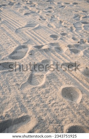 The background of a sandy beach with footprints. Sand beach background