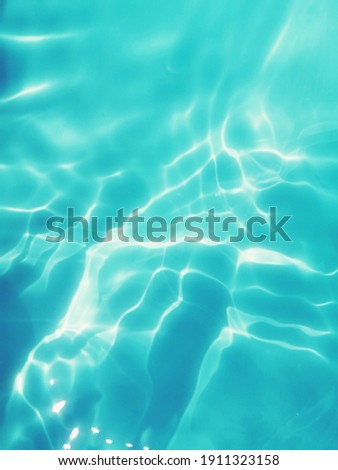Closeup​ blur​ abstract​ of​ surface​ blue​ water​ for​ background. Reflection​ on​ surface​ blue​ water​ in​ the​ sea.