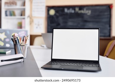 Background shot of laptop empty mockup screen on table in front of camera in primary school classroom, copy space - Powered by Shutterstock