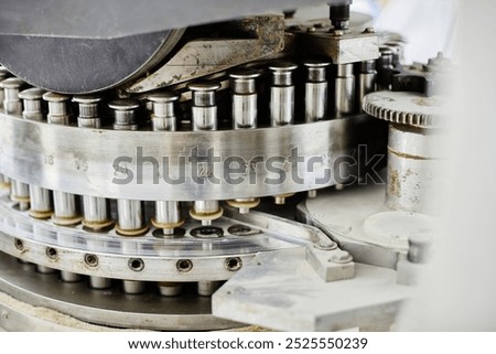 Background shot of punch tools in tablet press machine compressing powder into pills at pharmaceutical manufacturing plant, copy space