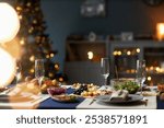 Background shot of roasted turkey and fruit platters served with salads on festive dinner table with empty champagne glasses while christmas lights glowing in blurred background, copy space