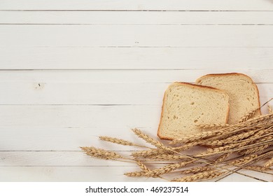 Background with slices of white bread and ears of wheat on white boards. Space for text. - Powered by Shutterstock