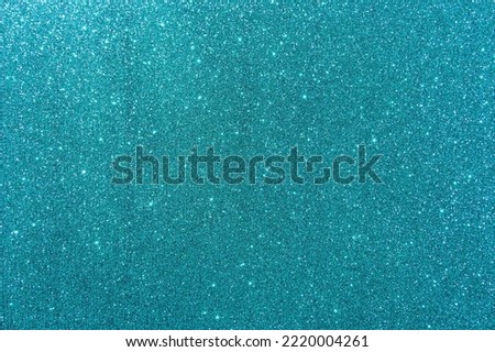 Background with sparkles. Backdrop with glitter. Shiny textured surface. Dark cyan. Soft light