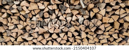 Background of stacked chopped wood logs. Pile of wood logs ready for winter. Wooden stumps, firewood stacked in heap 