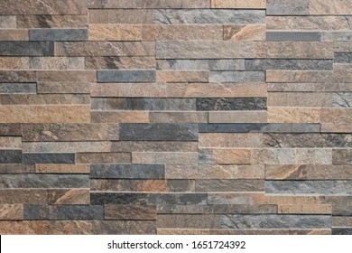 Background of stone wall made with blocks. New design of a modern wall as a background or texture. An example of masonry as an exterior wall cladding.