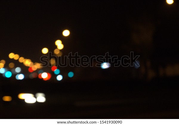 Background. The subject is out of focus (no\
sharpness). Night city road, traffic lights.On the road goes\
transport. For\
design