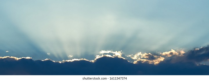 The background of sun rays over clouds. The sun rays break over the clouds.