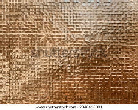 Background, the surface of the wall made of small tiles shimmers.
