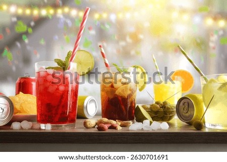 Background with a table with glasses of refreshing drinks, snacks, and cans with a festive background in a room with colored lights and confetti. Front view.