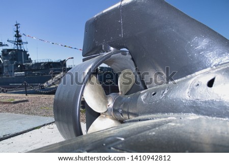 Background. Tail section of a miniature spy submarine mounted on a pier