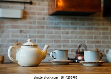 Background for tea ceremony in interior of kitchen area in cozy house. Teapot with mugs are on table waiting for tea with guests. Concept of home comfort and relaxation. Copy space - Powered by Shutterstock