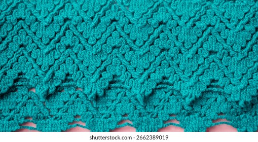 Background of teal lace pattern border. Close up of delicate turquoise blue green color floral lace embroidery pattern. Indian traditional artwork embroidered border with intricate ornamental flowers.