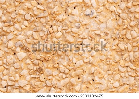 Background or texture Abstract of pebbles small or gravel color yellow, orange attached with beautiful cement concrete. Natural pattern used to make wallpaper website along walls of houses, building.	