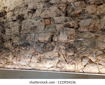 Background, texture or abstract:: Rounded stones set in wall illuminated with dramatic cross lighting