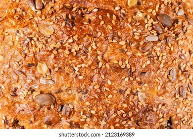 Background, texture of baked crust of healthy whole wheat bread of round shape with the addition of sesame seeds, sunflower, flax, pumpkin. Proper nutrition. Sourdough bread. - Shutterstock ID 2123169389