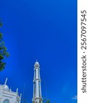 The background and texture of the clean blue sky, decorated with white mosque tower domes and green trees