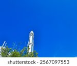 The background and texture of the clean blue sky, decorated with white mosque tower domes and green trees