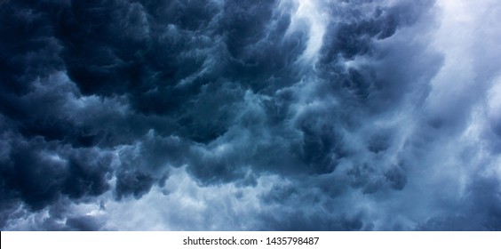 Background texture of dark storm clouds of the sky before a thunderstorm in rainy weather. Baner. Dramatic ominous dark blue clouds.