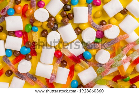 Background texture from different sweets on a yellow background. View from above