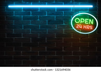 Background texture of empty red brick wall with blue neon light lamp, 80s style glow and and a colorful sign is open 24 hours a day