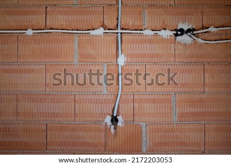 Background and texture of a freshly bricked wall. Slits were made in the masonry and conduits for the electrical system were drawn in.